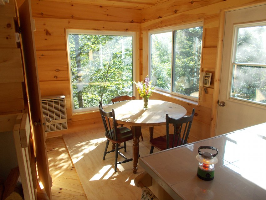 Sunny all-wood dining room with propane heater and corded telephone